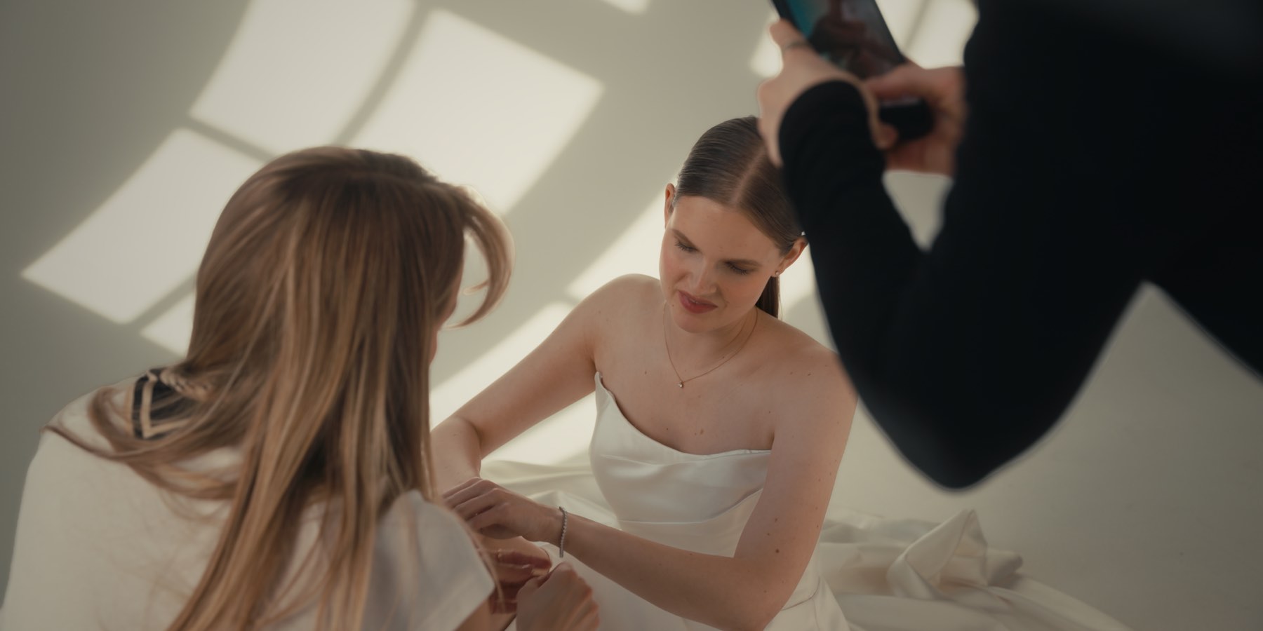 An ad being filmed on the Macor set: a phone recording the model being fitted with jewellery