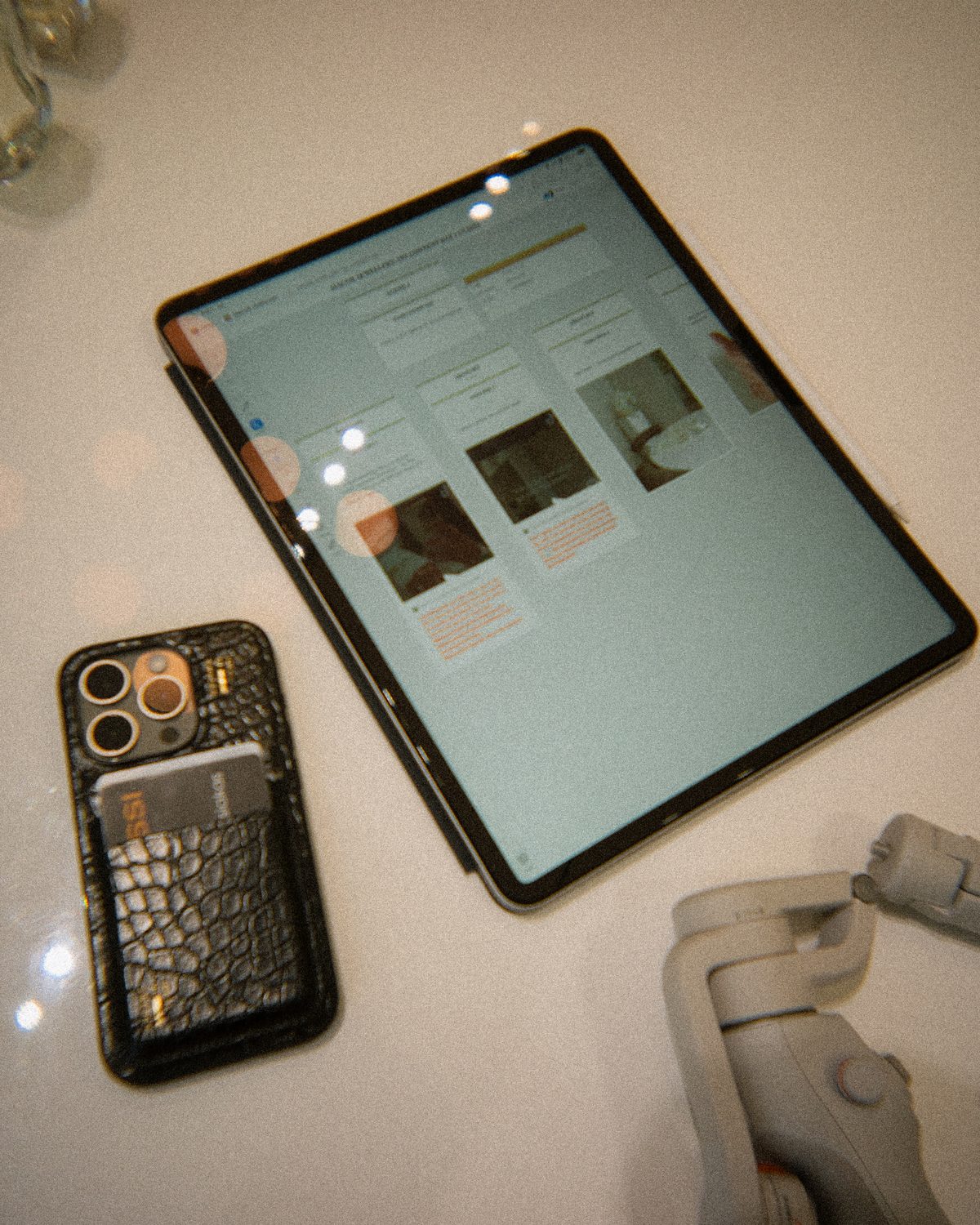 A social layout open on an iPad beside a phone on the desk